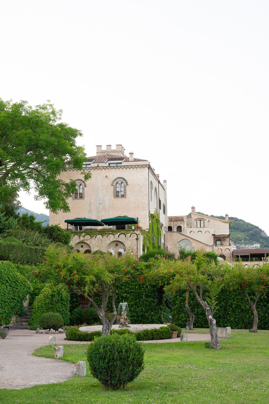 Exterior view of Villa Cimbrone surrounded by lush gardens and manicured hedges.