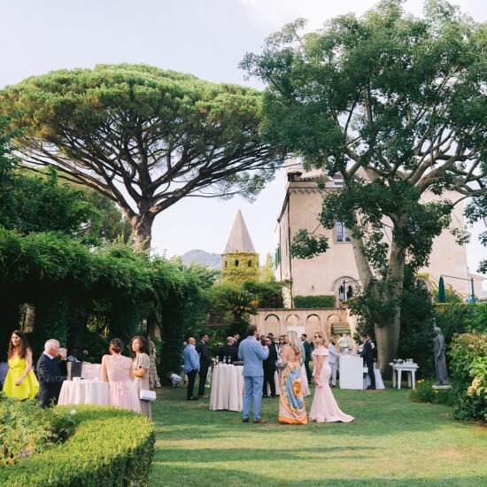 Guests enjoying a celebration in the lush gardens of Villa Cimbrone, surrounded by greenery and historic architecture.